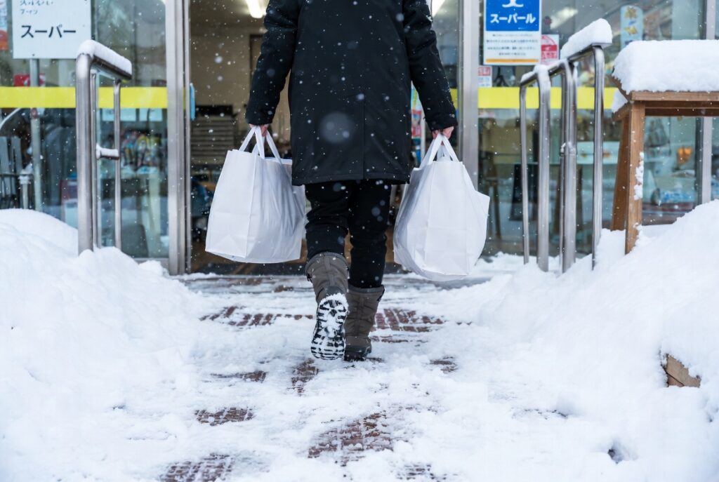 冬の札幌で車なしで重い日用品の買い出しをする大変さのイメージ